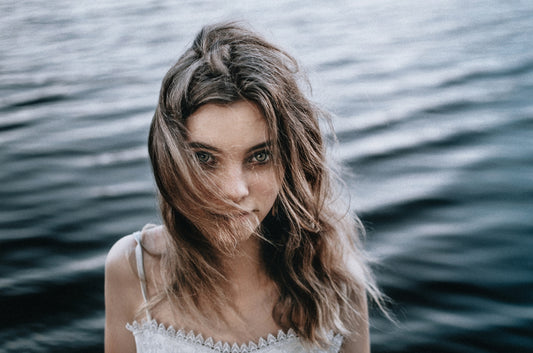 a woman standing in front of a body of water