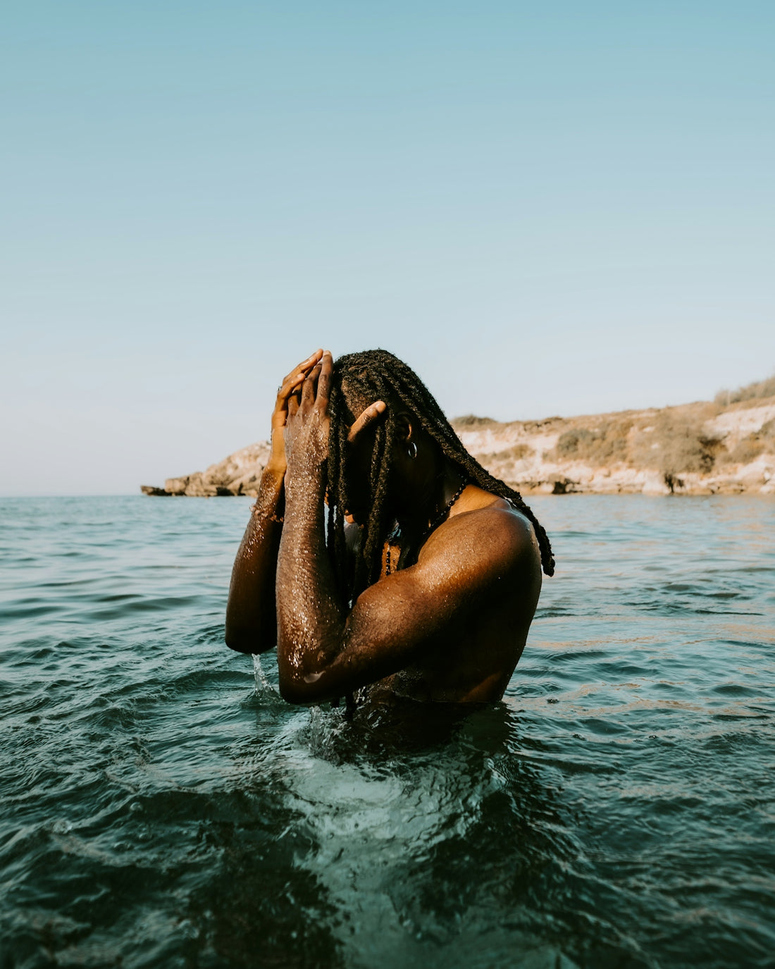 Man with dreadlocks in ocean water