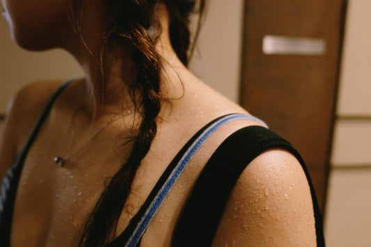 A person with a braided hairstyle and sweat droplets on their skin